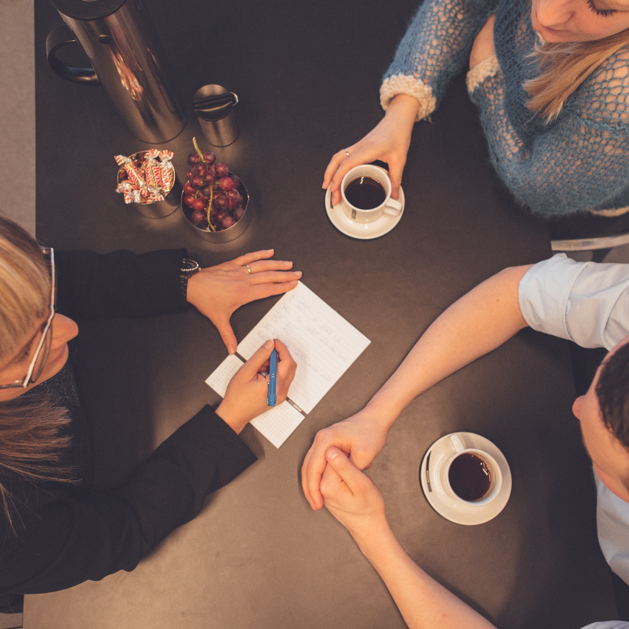 Tre mennesker til møde med kaffe
