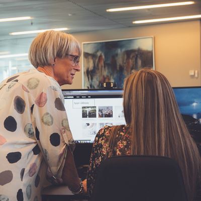 To kvinder ved en computerskærm på et kontor