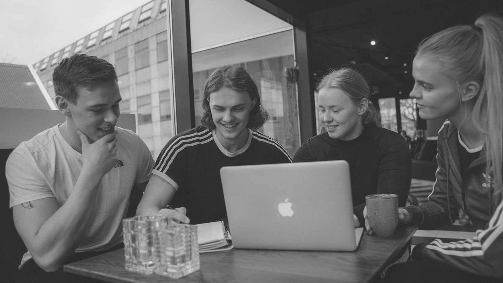 Unge, der laver gruppearbejde sort hvidt billede
