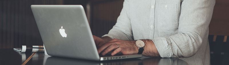Mand skriver på laptop