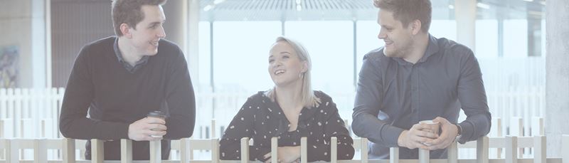 Tre unge mennesker står og taler sammen